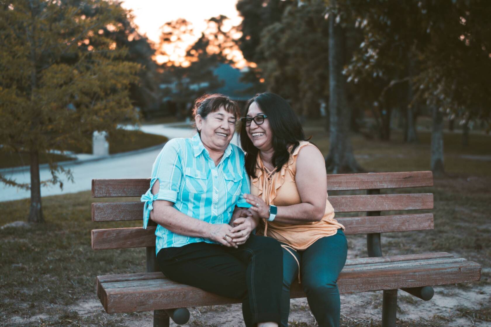 Women laughing on a park bench.