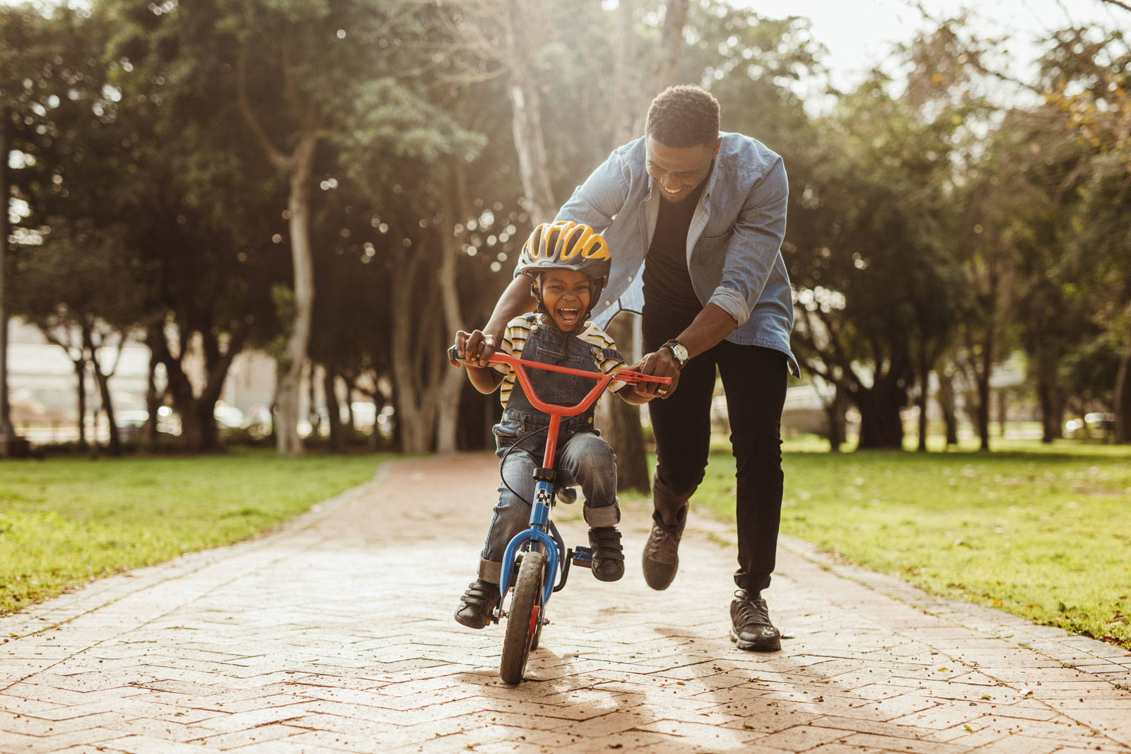 dad helping his son ride a bike