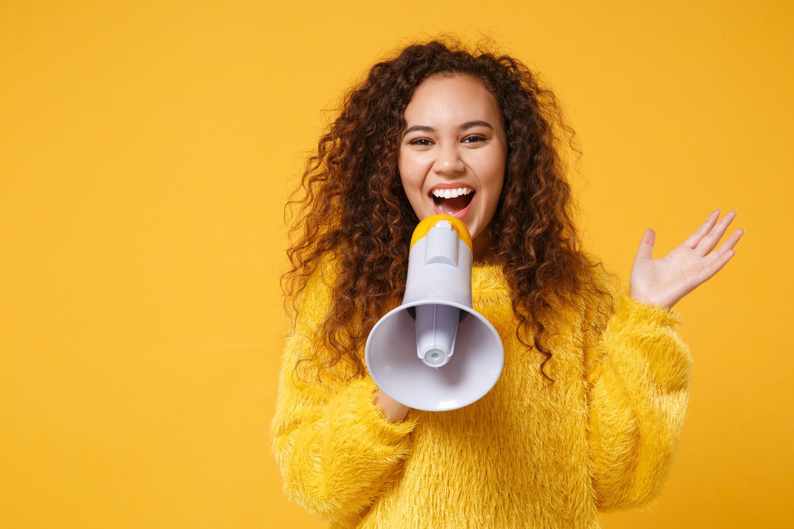 girl with yellow sweater holding a megaphone